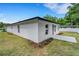 This corner of home features white exterior, dark roofline, landscaping and a concrete walkway at 1242 Dorothy St, Lakeland, FL 33815