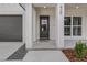 The front entrance to the home featuring a black front door, a house number, and a gray garage door at 1246 Dorothy St, Lakeland, FL 33815
