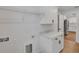 Well-lit laundry room with white cabinets, countertop, shelving, and access to the kitchen at 1246 Dorothy St, Lakeland, FL 33815
