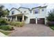 Charming two-story home with a well-manicured lawn, brick driveway, and a two-car garage at 13525 Gorgona Isle Dr, Windermere, FL 34786