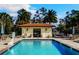 Community pool area with palm trees, lounge seating, and a covered entrance, perfect for relaxation at 13525 Gorgona Isle Dr, Windermere, FL 34786