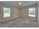 A bright carpeted bedroom featuring two windows and neutral paint at 1415 Southern Ave, Lakeland, FL 33803