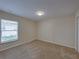 Bright bedroom boasts neutral walls, plush carpeting, and a window with blinds at 1415 Southern Ave, Lakeland, FL 33803