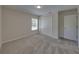A bright carpeted bedroom features a window and a closet with white doors at 1415 Southern Ave, Lakeland, FL 33803