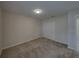 A carpeted bedroom features a closet with white doors and access to other rooms at 1415 Southern Ave, Lakeland, FL 33803