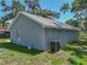 Side view of a home with gray siding, white trim, and a modern HVAC system on a well-maintained lawn at 1415 Southern Ave, Lakeland, FL 33803