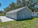 A home's exterior features a concrete driveway, green lawn, and a gray exterior paint at 1415 Southern Ave, Lakeland, FL 33803