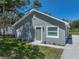 Single-story gray home with a new roof, white trim, and a green front door is nicely landscaped at 1415 Southern Ave, Lakeland, FL 33803