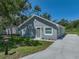 Single-story gray home with new landscaping, white trim and a green front door in a peaceful setting at 1415 Southern Ave, Lakeland, FL 33803