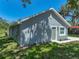 Newly renovated gray home featuring white trim, a green front door, and fresh landscaping on a sunny day at 1415 Southern Ave, Lakeland, FL 33803