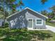 Charming gray home featuring white trim, a green front door, and new landscaping, with mature trees at 1415 Southern Ave, Lakeland, FL 33803