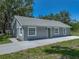 Gray one-story home featuring white trim, a new roof, and a freshly poured concrete sidewalk and driveway at 1415 Southern Ave, Lakeland, FL 33803