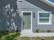 Charming gray house featuring a green front door with white trim, new landscaping, and matching window trim at 1415 Southern Ave, Lakeland, FL 33803