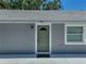 Welcoming gray home featuring a green front door with new hardware, white trim, and manicured landscaping at 1415 Southern Ave, Lakeland, FL 33803
