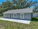 Gray single-story home featuring a new roof, green front door, and a freshly poured concrete sidewalk at 1415 Southern Ave, Lakeland, FL 33803