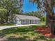 Quaint home with gray exterior, crisp white trim, and lush green yard, shaded by mature trees at 1415 Southern Ave, Lakeland, FL 33803