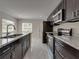 Open kitchen with gray tile flooring, granite countertops, stainless steel appliances, and a functional design at 1415 Southern Ave, Lakeland, FL 33803