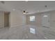 Bright living room with neutral walls, ceiling fan, and gray tile floors reflecting natural light from the window at 1415 Southern Ave, Lakeland, FL 33803