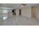 Open-concept living room with gray tile floors flowing into an adjacent kitchen and bedrooms at 1415 Southern Ave, Lakeland, FL 33803