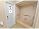 Bathroom with beige tile surround, shower and bathtub, grab bars, and tropical themed door at 1628 Lakewood S Dr, Lakeland, FL 33813