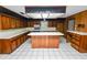 A kitchen showcasing wood cabinets, a center island with white countertop, and tile flooring at 1628 Lakewood S Dr, Lakeland, FL 33813