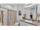Simple bathroom features a shower with curtain, modern sink and neutral paint at 1725 Hill Top Dr, Dundee, FL 33838