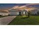 Charming single-story home with neutral siding, attached garage, and manicured lawn under a colorful sky at 1725 Hill Top Dr, Dundee, FL 33838