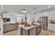 Open-concept kitchen with stainless appliances, island with seating, open to dining and living area at 1725 Hill Top Dr, Dundee, FL 33838