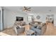 Bright living room with neutral furniture, ceiling fan, large TV, and beige tile flooring at 1725 Hill Top Dr, Dundee, FL 33838