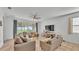 Bright open living area with a ceiling fan, sliding glass doors to the patio, tile floors, and couches at 1725 Hill Top Dr, Dundee, FL 33838