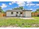 The backyard features a small concrete patio, privacy fence, and an exterior door at 1728 Bush Ave, Lakeland, FL 33805