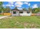 One-story home featuring white siding, dark shutters, a well-maintained lawn, and fresh landscaping at 1728 Bush Ave, Lakeland, FL 33805