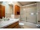 Full bathroom with vanity, commode and a tub with a glass door at 1920 Indian Trails Ct, Lakeland, FL 33813