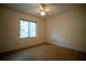 A carpeted bedroom featuring a ceiling fan, a window, and neutral colored walls at 1920 Indian Trails Ct, Lakeland, FL 33813