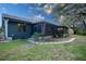 Back of home featuring large screened lanai with access to backyard and mature landscaping at 1920 Indian Trails Ct, Lakeland, FL 33813