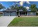 Charming single-story home featuring a screened porch, attached garage, and well-maintained lawn at 1920 Indian Trails Ct, Lakeland, FL 33813