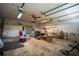 A spacious and cluttered garage with exposed beams, ceiling fan, and shelving units at 1920 Indian Trails Ct, Lakeland, FL 33813