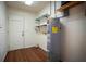 A utility room featuring wood floors, shelves and a hot water tank at 1920 Indian Trails Ct, Lakeland, FL 33813