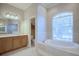 Bathroom with a soaking tub and arched window; bright and spacious at 2032 Indian Sky Cir, Lakeland, FL 33813