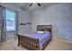 Cozy bedroom with a wooden bed frame, ceiling fan and an eye-catching accent wall at 2032 Indian Sky Cir, Lakeland, FL 33813