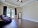 Bedroom with tray ceilings, hardwood floors, and a doorway leading to the pool at 2032 Indian Sky Cir, Lakeland, FL 33813