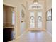Welcoming foyer with decorative glass double doors, transom window, and neutral tile flooring at 2032 Indian Sky Cir, Lakeland, FL 33813