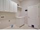 Bright laundry room featuring white cabinets, sink, and neutral wall paint at 2032 Indian Sky Cir, Lakeland, FL 33813