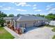 Rear exterior view of a house with a paved walkway, three car garage and neutral exterior paint at 2032 Indian Sky Cir, Lakeland, FL 33813