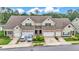 Attractive townhome showcasing a mix of stone and siding, attached garages, and verdant landscaping at 2047 Winterset Dr, Lakeland, FL 33813