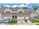 Inviting townhome displaying a blend of stone and siding, attached garages, and lush landscaping at 2047 Winterset Dr, Lakeland, FL 33813