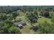 Aerial view of the home, outbuildings, and large yard with mature trees at 2145 Limedale Rd, Lakeland, FL 33809