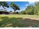 Expansive backyard featuring a large shade tree and manicured lawn adjacent to the home at 2145 Limedale Rd, Lakeland, FL 33809