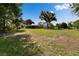 View of the home's exterior and a huge grassy lawn with mature trees at 2145 Limedale Rd, Lakeland, FL 33809