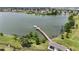 Aerial view of the lake with a long dock surrounded by lush greenery and serene blue water at 2293 Caspian Dr, Lakeland, FL 33805